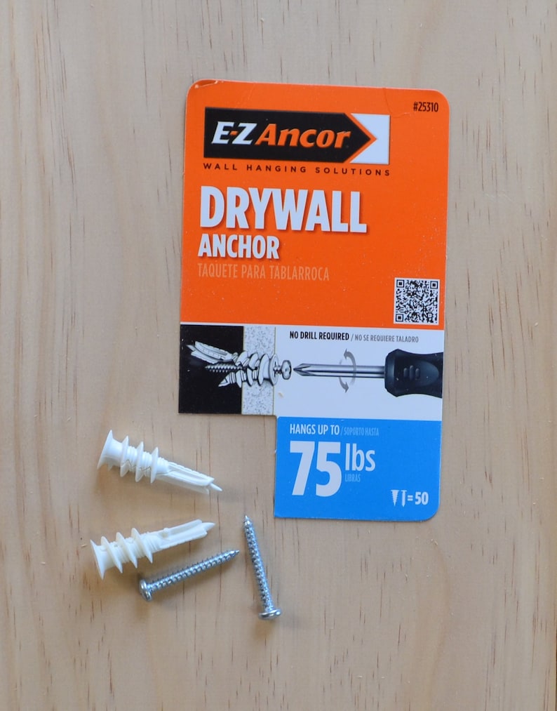 Puede incluir: Un primer plano de un paquete de anclaje para paneles de yeso con un anclaje de pl&aacute;stico blanco y un tornillo. El paquete es naranja y azul y dice "E-Z Ancor" y "Drywall Anchor". El anclaje est&aacute; clasificado para 75 libras.
