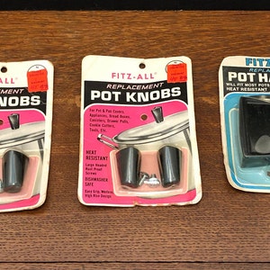 May include: Three packages of replacement pot knobs and handles. The packages are white with black text and images of the products. The knobs are black and the handles are black. The text on the packages reads "Fitz-All Replacement Pot Knobs" and "Fitz-All Replacement Pot Handles".