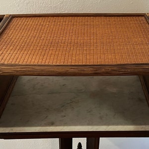 May include: A brown wicker tray with two side compartments. The tray is made of woven wicker and has a natural wood finish. The tray is perfect for serving snacks or drinks.