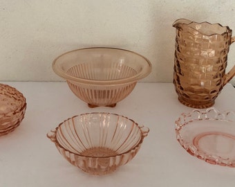 Puede incluir: Conjunto de cinco cuencos de vidrio rosa con diferentes patrones y formas. Los cuencos están hechos de vidrio transparente con un tinte rosa. Los cuencos están todos en buen estado y no tienen astillas ni grietas.
