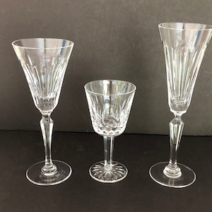 May include: Three clear glass drinking glasses with different shapes and sizes. The glasses have a cut crystal design.