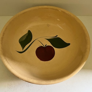 May include: A yellow ceramic bowl with a hand-painted design of a red apple with green leaves.