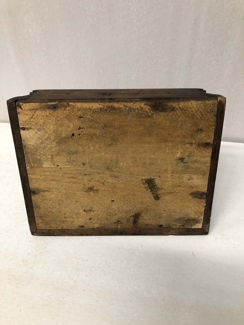 May include: A wooden box with a plain, light brown interior. The box is closed and the lid is not visible.
