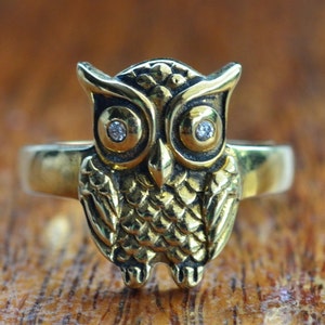 May include: A gold owl ring with two clear rhinestones for eyes.