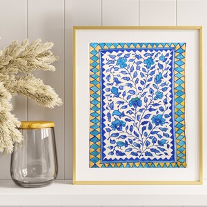 May include: A framed print of a blue and white floral pattern with a gold frame. The pattern is reminiscent of traditional Indian art.