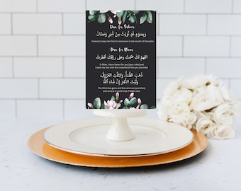 Puede incluir: Una tarjeta negra con acentos florales y dos oraciones islámicas escritas en escritura árabe. El texto se traduce como "Tengo la intención de ayunar mañana en el mes de Ramadán" y "Oh Allah, he ayunado por ti (por tu bien) y abro mi ayuno con el sustento que has provisto".