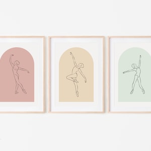 以下が含まれることがあります： アーチ型の入り口に立つバレリーナの線画が描かれた額装されたプリント3枚。プリントはピンク、ベージュ、グリーンの背景です。