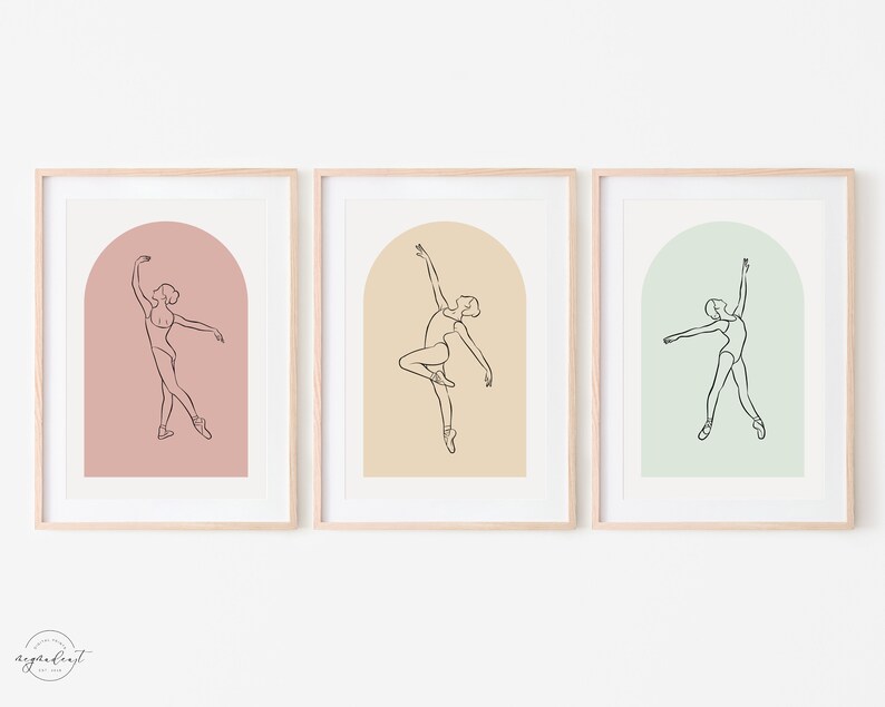 May include: Three framed prints with a line drawing of a ballerina in an arched doorway. The prints have a pink, beige, and green background.