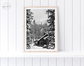 Könnte beinhalten: Schwarzweiß-Illustration einer Hütte in einem schneebedeckten Wald. Die Hütte hat ein schneebedecktes Dach und einen Schornstein. Die Bäume sind hoch und kahl, und der Boden ist mit Schnee bedeckt.