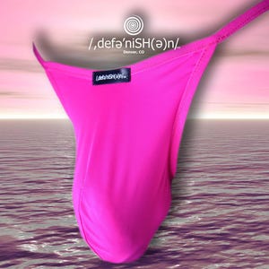 Può includere: Perizoma rosa acceso con un design a sottile spallina. Il capo ha una piccola etichetta nera con testo bianco. Lo sfondo è una sfumatura rosa e viola su una superficie simile all'acqua.