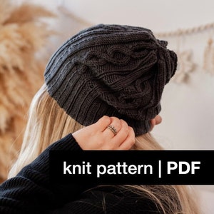 May include: A gray knit hat with a cable knit pattern. The hat is being worn by a person with long blonde hair. The text "knit pattern | PDF" is visible on the image.