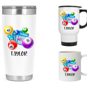 May include: Three white mugs with a design of colorful bingo balls and a bingo card. The text "TAYLOR" is on each mug.