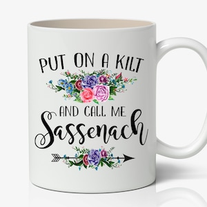 May include: White ceramic coffee mug with a black floral design and the text "Put on a kilt and call me Sassenach".