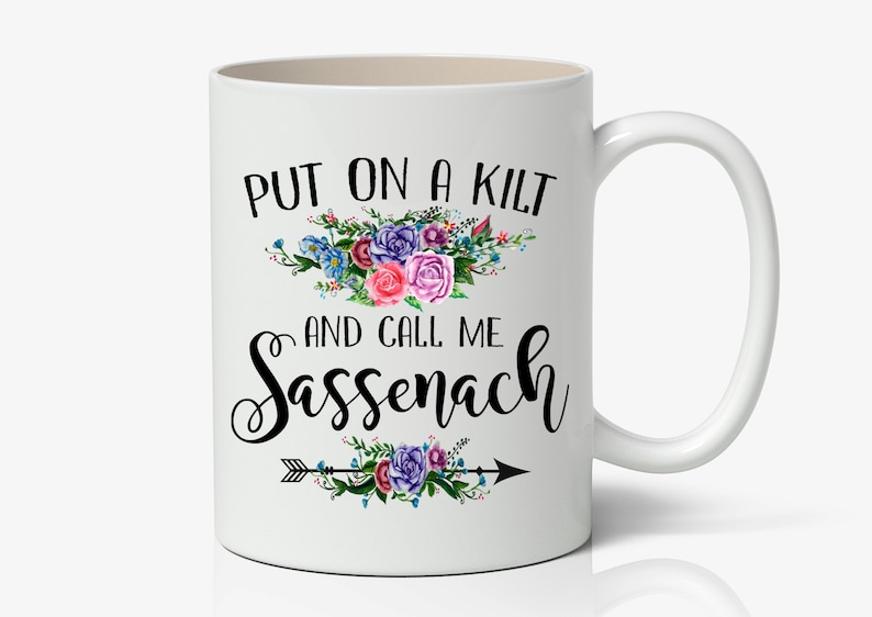 May include: White ceramic coffee mug with a black floral design and the text "Put on a kilt and call me Sassenach".