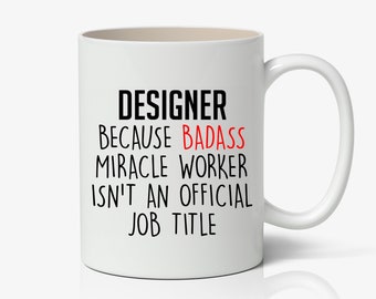 May include: White ceramic coffee mug with black text that reads "Designer because badass miracle worker isn't an official job title". The word "badass" is in red.