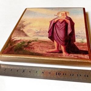 K&ouml;nnte beinhalten: Rechteckige Holztafel mit einem religi&ouml;sen Gem&auml;lde. Das Kunstwerk zeigt eine Figur in einem lila Gewand, die einen Stab h&auml;lt, vor einer Landschaft mit Sonnenuntergang. Die Tafel ist goldfarben gerahmt.
