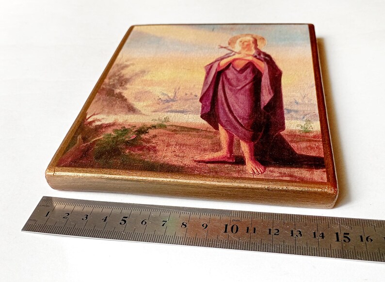 K&ouml;nnte beinhalten: Rechteckige Holztafel mit einem religi&ouml;sen Gem&auml;lde. Das Kunstwerk zeigt eine Figur in einem lila Gewand, die einen Stab h&auml;lt, vor einer Landschaft mit Sonnenuntergang. Die Tafel ist goldfarben gerahmt.