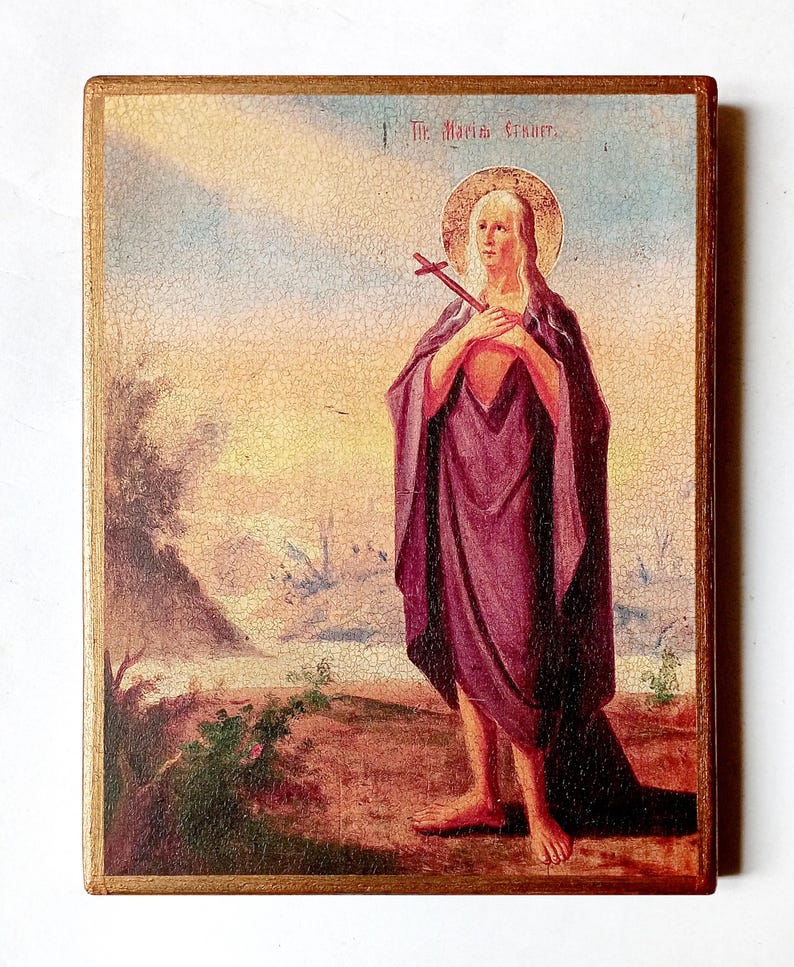 K&ouml;nnte beinhalten: Vintage religi&ouml;se Ikone mit einer Figur mit Heiligenschein, die ein Kreuz h&auml;lt. Die Figur ist in ein lila Gewand geh&uuml;llt, vor einer Landschaft mit goldenem Rahmen. Der Text "St. Maria E." ist oben sichtbar.