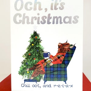 May include: A Christmas card featuring a cartoon Highland cow wearing a red tartan robe and relaxing in a tartan armchair with a mug of hot chocolate. The cow is looking up at a Christmas tree with a star on top. The text on the card reads "Och, it's Christmas Chill oot, and r-e-l-a-x".