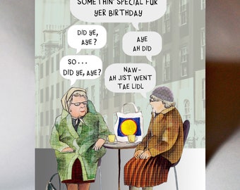 May include: A humorous greeting card featuring an illustration of two older women in coats and hats, conversing at a table. Speech bubbles contain text in a Scottish dialect. A shopping bag with a yellow circle is on the table.