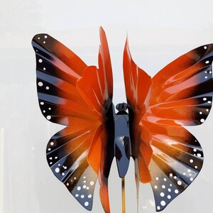 May include: Orange and black metal butterfly garden stake with white polka dots.