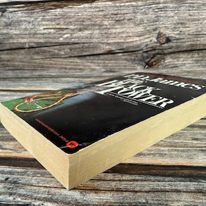 May include: A hardcover book titled "The Black Tower" by John Fowles. The book has a black cover with white text and a colorful illustration. The book's pages are aged, and the spine is visible.