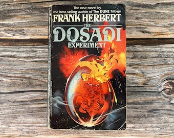 May include: A book cover with a black background and a large, cracked egg in the center. The egg is filled with a fiery orange glow and a city inside. The title "The Dosadi Experiment" is written in white letters above the egg. The author's name, "Frank Herbert", is written in white letters above the title.