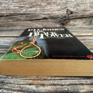 May include: A paperback book titled "Black Tower" by B.D. James. The cover features a noose and key illustration against a dark background. The book's pages are aged, and the spine is visible.