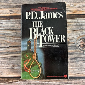 May include: A vintage paperback book titled "The Black Tower" by P.D. James. The cover is black with white lettering and features a lighthouse illustration with a noose and key. The book is a Warner Books edition.