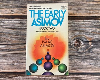 May include: The Early Asimov Book Two, a paperback book cover with a bright orange and yellow background featuring a stylized image of a cluster of spheres. The text on the cover reads "The Early Asimov" in blue and "Book Two" in black. The author's name, "Isaac Asimov", is printed in black below the title.