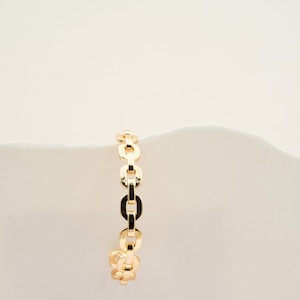 May include: A gold chain bracelet with a simple, linked design.