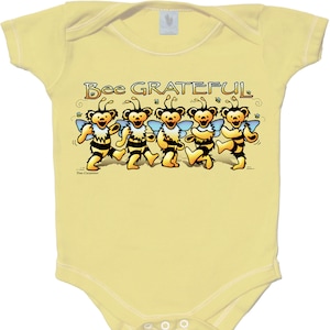 May include: A yellow baby onesie with a graphic of five dancing bears dressed as bees. The text "Bee Grateful" is above the bears.