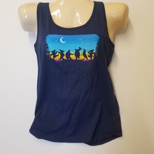 May include: A navy blue tank top with a graphic of a group of dancing bears, a turtle, a bird, and a raccoon under a crescent moon and stars. The graphic is in rainbow colors.