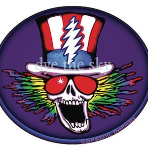 May include: A purple circle with a skull wearing red sunglasses and a red, white, and blue top hat. The skull has a lightning bolt on its forehead and a rainbow of colors radiating from its head. The text "dye the sky" is written on the hat.
