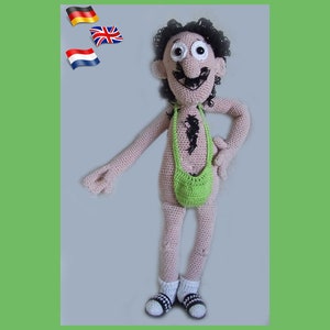 May include: A crocheted doll with brown hair, a green pouch, and black and white shoes. The doll is standing with its right hand on its hip.