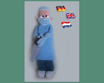May include: A crocheted plush toy doctor wearing a blue surgical gown, a white surgical cap, and a blue face mask. The toy is holding a brown and white medical tool. The background features three flags: German, British, and Dutch.