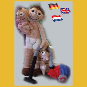May include: A crocheted doll with a brown body and a white undershirt is holding two smaller crocheted dolls. The doll is holding a blue and red toy vacuum cleaner. The background is a light grey with flags of Germany, the United Kingdom, and the Netherlands.