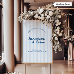 Pode incluir: Um sinal de casamento listrado azul e branco com o texto "Bem-vindos ao nosso casamento Genevieve e Liam 28 de junho de 2026 Montecito, Calif&oacute;rnia".