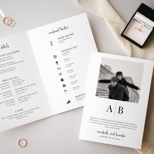 May include: A wedding invitation suite featuring a tri-fold timeline, a photo card, and a ring box. The timeline lists wedding events with icons. The photo card has a black and white photo of a couple. Gold rings are visible.