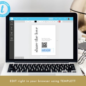 May include: A laptop screen displaying a wedding photo booth sign with a QR code and the text "share the love" and "[couple's names] and [date]" in a blue box. The sign is on a white background. The laptop is open and the screen is showing a website with a menu bar and a toolbar.