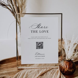 Könnte beinhalten: Ein weißes Schild mit goldenem Rahmen, mit dem Text "Share the Love" und einem QR-Code. Der Text unter dem QR-Code lautet "Lillianna und Matthew, 29. September 2023".