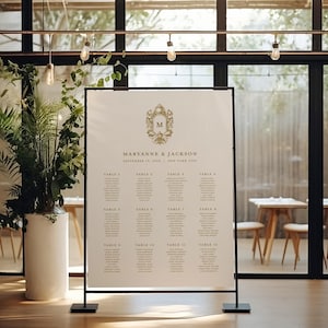 Könnte beinhalten: Ein weißer Hochzeitssitzplan mit einem goldenen Monogramm und den Namen "Maryanne & Jackson" sowie dem Datum "16. September 2020" und dem Ort "New York City". Der Plan listet die Tische 1 bis 15 mit den Namen der Gäste auf.