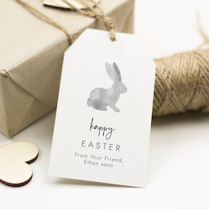 May include: A white gift tag with a watercolor gray bunny illustration. The tag says "happy easter" and "From your friend, Ethan xoxo".
