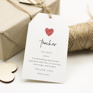 May include: A white gift tag with a red heart and the word "teacher" written in black cursive. The tag also includes the definition of the word "teacher" and the text "Thank You Anna xoxo".