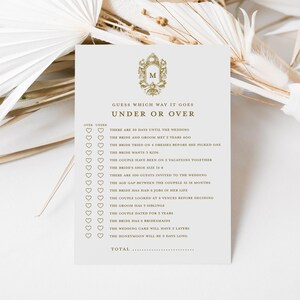 May include: A printable wedding game card with the title "Guess Which Way It Goes Under or Over". The card has a list of 15 wedding-related questions with "Over" and "Under" options for each question. The card is decorated with a gold crest.