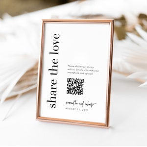 May include: A white sign with a black frame, a QR code, and the text "share the love". The text below the QR code reads "Please share your photos with us. Simply scan with your smartphone and upload." The text at the bottom of the sign reads "Samantha and Roberto August 23, 2023".
