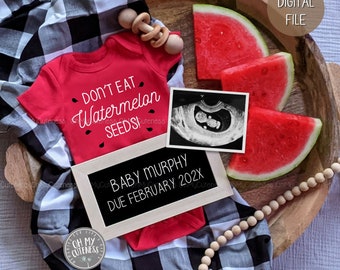 May include: A red onesie with the text "Don't Eat Watermelon Seeds!" on it, a black and white checkered blanket, a wooden tray with watermelon slices, a wooden rattle, a black and white ultrasound image, and a chalkboard sign that reads "Baby Murphy Due February 202X".