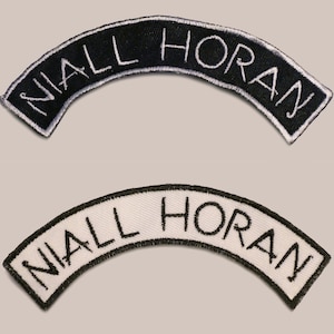 May include: Two embroidered patches, one black with white stitching and one white with black stitching, both with the text "NIALL HORAN" in a curved arc.