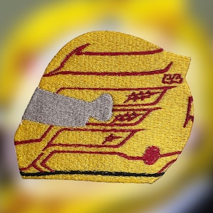 May include: An embroidered patch shaped like a racing helmet in bright yellow with dark red linear accents and a grey visor section. The design features horizontal red lines across the yellow surface and a small red circular detail at the bottom.
