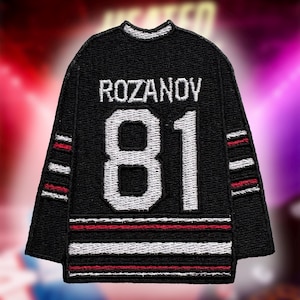 以下が含まれることがあります： 黒いホッケーのジャージパッチ。名前「ROZANOV」と番号「81」が白で表示されています。ジャージには袖と裾に赤と白のストライプがあります。パッチは衣服に縫い付けたり、アイロンをかけたりするように設計されています。